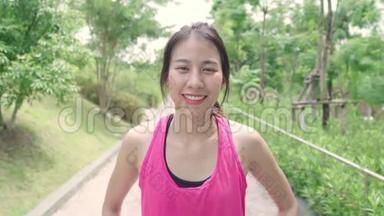 健康美丽的年轻亚洲<strong>跑</strong>步女子在城市公园的街道上<strong>跑</strong>步后，感到快<strong>乐</strong>的微笑和寻找相机。